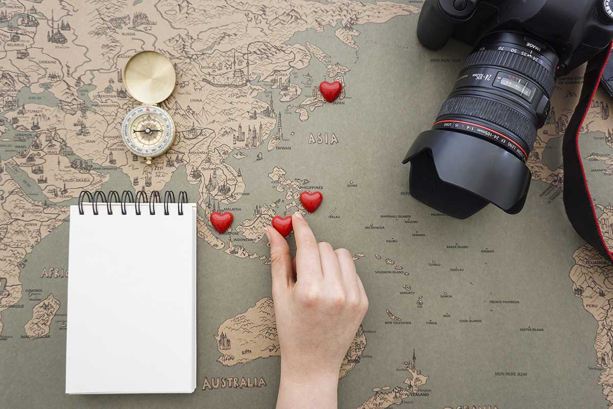travel background with hand placing hearts world map copy